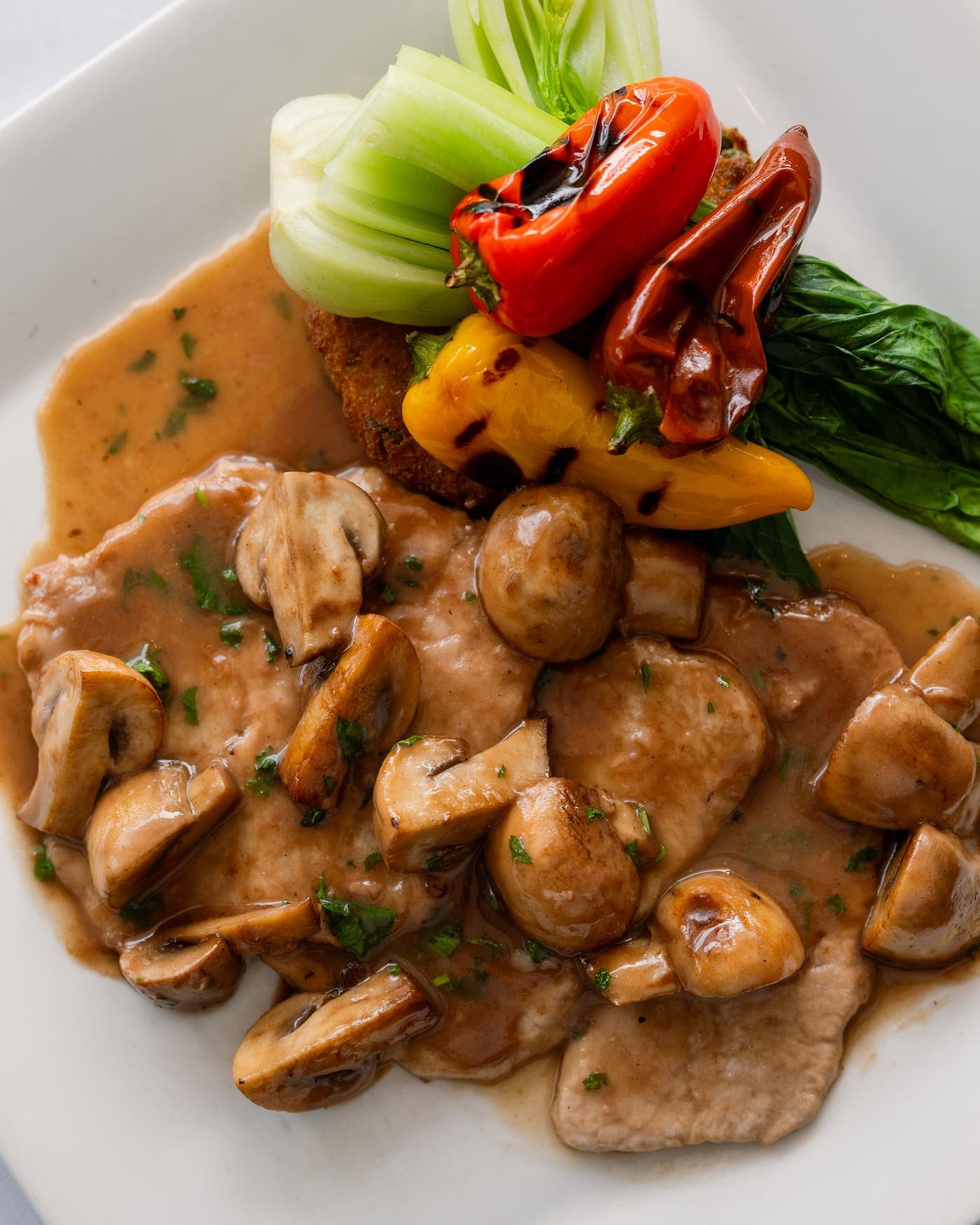 Veal scaloppine in mushroom sauce with grilled peppers and bok choy